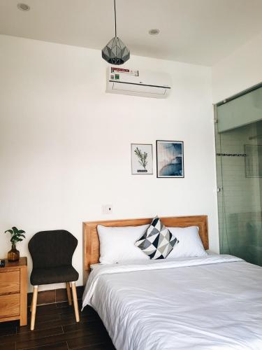a bedroom with a bed and a chair at K73 De HOUSE in Danang