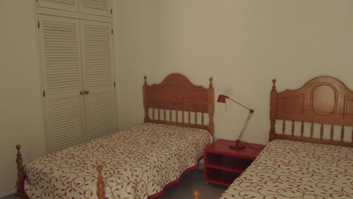2 camas en un dormitorio con paredes blancas y puertas blancas en Apartment Vila Rosa, en Portimão