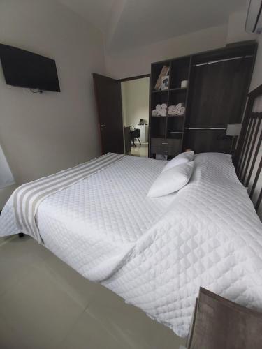 una camera da letto con un grande letto con lenzuola bianche di Moreno Apart a San Miguel de Tucumán