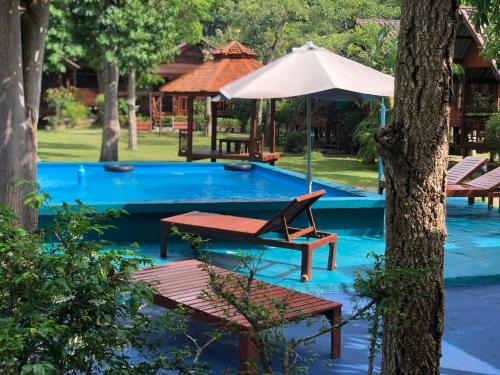 a swimming pool with a chair and an umbrella at Haad Salad Resort in Salad Beach