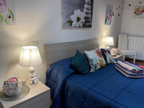 a bedroom with a blue bed and two lamps at Appartamento Via G Mameli 94 in Spoleto