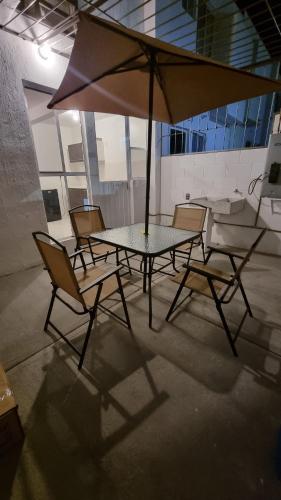 a table and chairs with an umbrella on a patio at Allisson's House in Emiliano Zapata