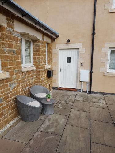 a patio with two benches and a building at The Stables a Contractor Family 2 bed Town House in Central Melton Mowbray in Melton Mowbray