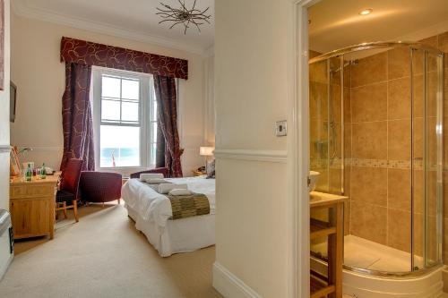 a bedroom with a bed and a shower at Hotel Prince Regent in Weymouth