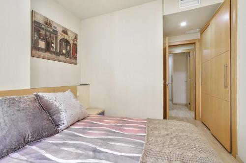 a bedroom with a bed and a door to a hallway at Apartamento en primera línea de playa en Málaga in Málaga
