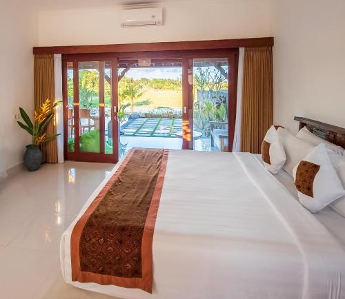 1 dormitorio con 1 cama grande y balcón en Uma Jala Villa Ubud en Ubud