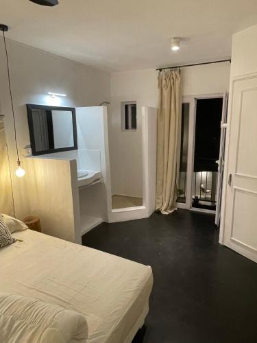 a bedroom with a bed and a desk and a window at Cosy Guest House Sous le Badamier in Grand Baie