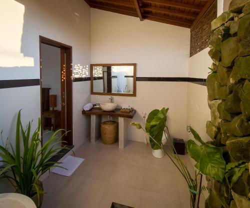 uma casa de banho com um lavatório e um espelho em Uma Jala Villa Ubud em Ubud