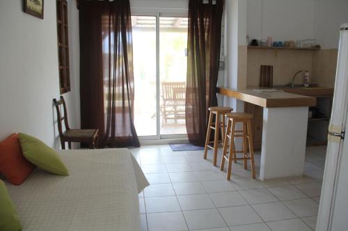 a bedroom with a bed and a kitchen with a counter at Keravel Bungalows in Pointe d'Esny