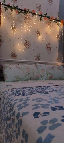 a bed with a head board with lights on it at The Floral Home in Melaka