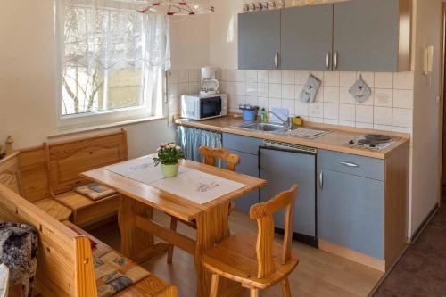 une cuisine avec une table en bois, une table et des chaises dans l'établissement Gästehaus Bechtloff, à Meissen