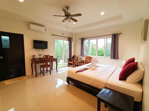 a bedroom with a large bed and a dining room at Baan Glangsuan Bang Kobua in Bang Chak