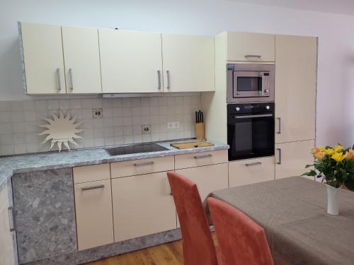 a kitchen with white cabinets and a table with a tableablish at Ferienwohnungen Stranddistel - Apartments von 30 bis 75 qm in Zinnowitz