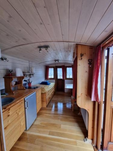 uma cozinha com piso em madeira e um tecto em madeira em Roulotte du domaine de la Graou em La Palud sur Verdon
