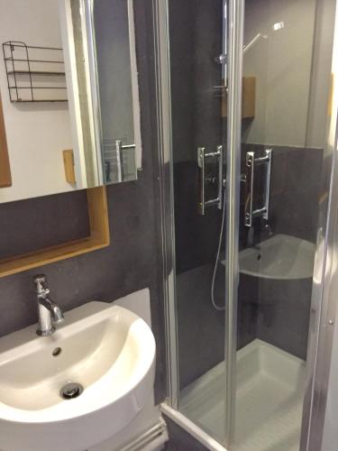 une salle de bain avec un lavabo et une douche dans l'établissement LE ROC, à Granville