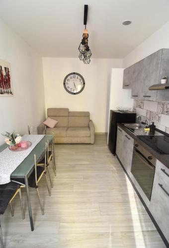 cocina y sala de estar con mesa y sofá en BLhouse en Turín