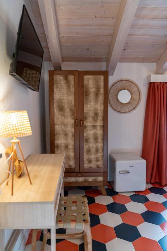 a room with a desk and a tv and a floor at Suitetti Camere&Relax in San Nicola Arcella
