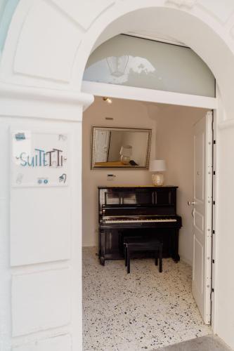 an archway leading into a room with a piano at Suitetti Camere&Relax in San Nicola Arcella
