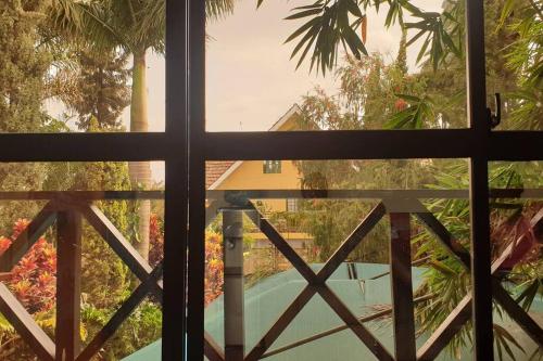 a window with a view of a swimming pool at The Annex at 64 : Cozy, rustic cottage/treehouse in Nairobi