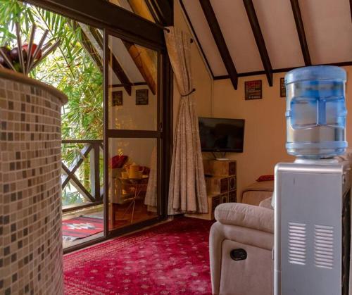 a living room with a water tank on a refrigerator at The Annex at 64 : Cozy, rustic cottage/treehouse in Nairobi