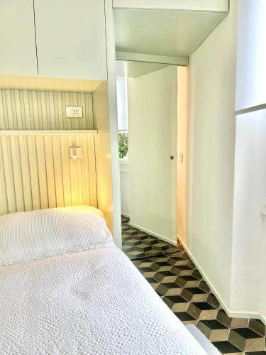 a bedroom with a white bed and a mirror at About Italy Holiday Rooms and Apartments in Portovenere