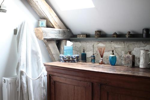 una estantería de madera con jarrones en una habitación en Le clos des artistes - Chambres d'hôtes, en Turny
