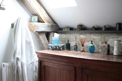 a wooden shelf with vases on it in a room at Le clos des artistes - Chambres d'hôtes in Turny