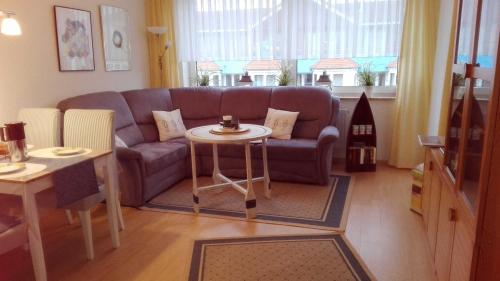 クックスハーフェンにあるVogelsand 343の紫色のソファとテーブル付きのリビングルーム