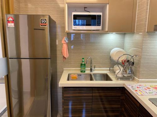 a kitchen with a stainless steel refrigerator and a sink at R&F Princess Cove JB Apartment Suites By SC Homestay in Johor Bahru