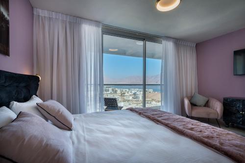 1 dormitorio con cama grande y ventana grande en Geffen penthouse pool & view, en Eilat