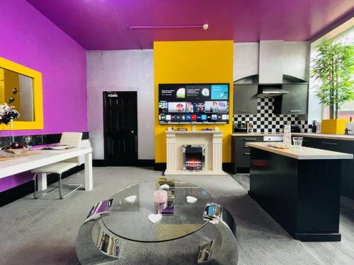 a living room with a glass table and a fireplace at PHOENIX Apartments in Goole