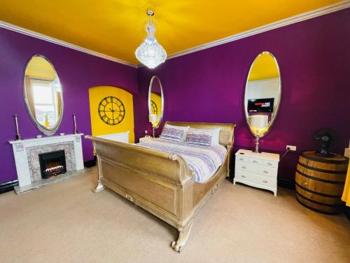 um quarto com uma cama com paredes e espelhos roxos em PHOENIX Boutique Apartments em Goole