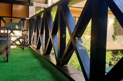a wooden bridge with green grass underneath a building at The Annex at 64 : Cozy, rustic cottage/treehouse in Nairobi