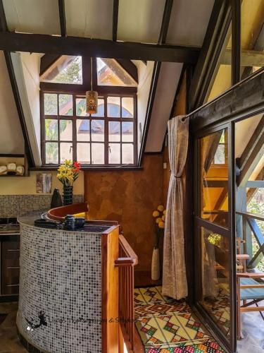 a kitchen with a large window and a room with a tub at The Annex at 64 : Cozy, rustic cottage/treehouse in Nairobi