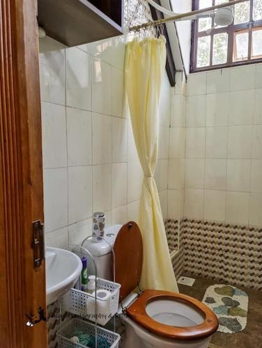 a bathroom with a toilet and a sink at The Annex at 64 : Cozy, rustic cottage/treehouse in Nairobi