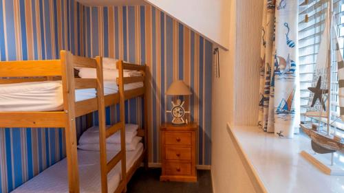 a bedroom with a bunk bed and a staircase at Fisherman's Cottage in Newbiggin-by-the-Sea