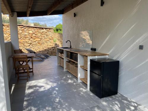 eine Küche mit einer Theke und einem Waschbecken auf einer Terrasse in der Unterkunft Chambre à louer in Laouque