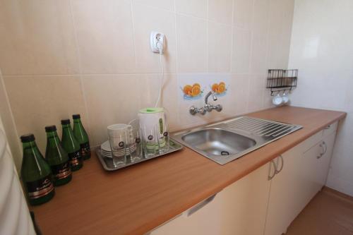 a kitchen with a sink and a counter with bottles at Sunset Przymorze in Rewal