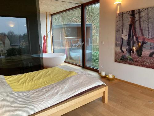 a bedroom with a bed and a large window at Poolvilla in Caputh