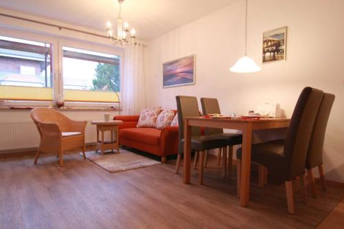 een woonkamer met een tafel en stoelen en een bank bij Vogelsand 324 in Cuxhaven