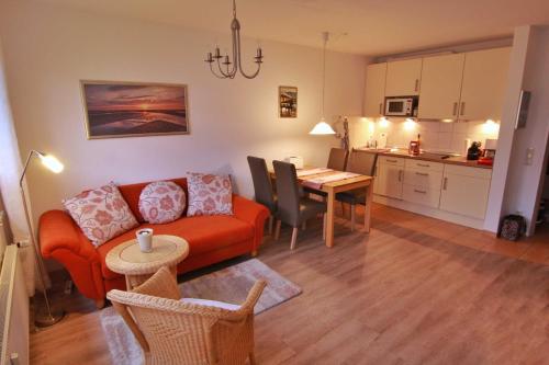 een woonkamer met een bank en een tafel en een keuken bij Vogelsand 324 in Cuxhaven