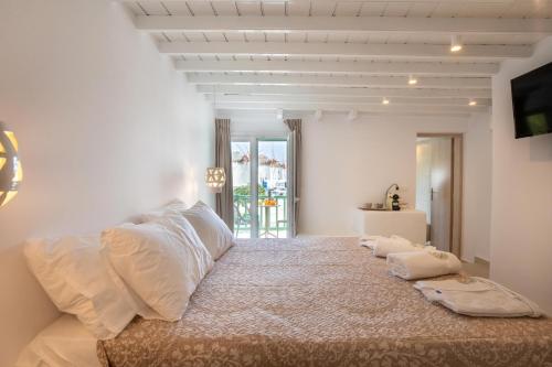 a bedroom with a large bed with pillows on it at Mylos Suites in Mýkonos City