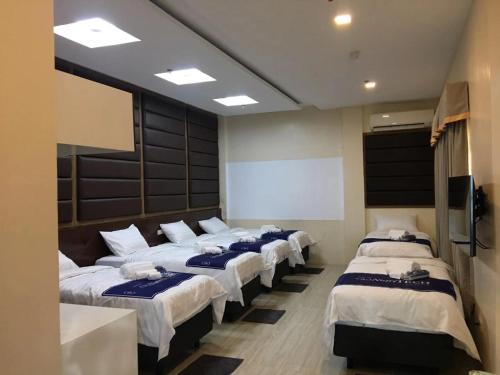 grupa czterech łóżek w pokoju w obiekcie NutriTECH Hotels & Events w mieście Calapan