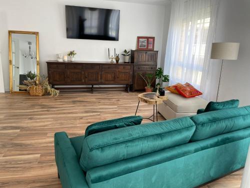 a living room with a green couch and a tv at Apartamento Dakota in Sant Carles de la Ràpita