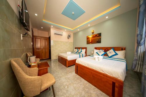 a hotel room with two beds and a chair at KHÁCH SẠN HOÀNG SƠN in Con Dao