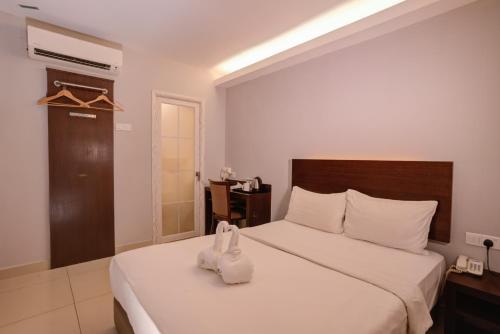 a bedroom with a large white bed with white towels on it at GM Hotel Metro at Sunway in Petaling Jaya