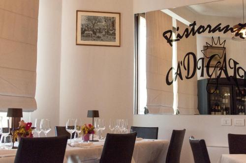 a dining room with white tables and chairs and a window at Hotel Ca' di Gali in Sasso Marconi