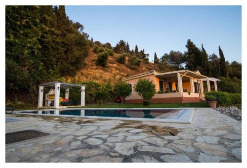 a house with a swimming pool in front of a house at Private Villa's in NW Corfu with Pool in Kavvadádes