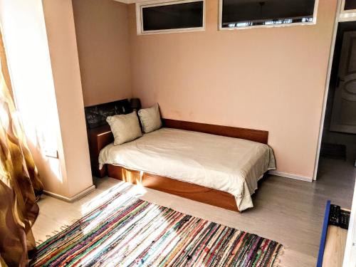 een kleine slaapkamer met een bed en een tapijt bij Апартамент "Скален венец" in Veliko Tŭrnovo