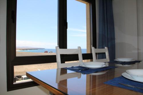 a dining table with two chairs and a view of the ocean at Apartamento (Cotillo Mar) con vistas al Mar in Cotillo